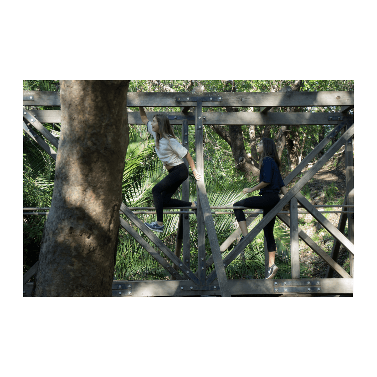 Bract apparel young women climbing bridge in bract shirts