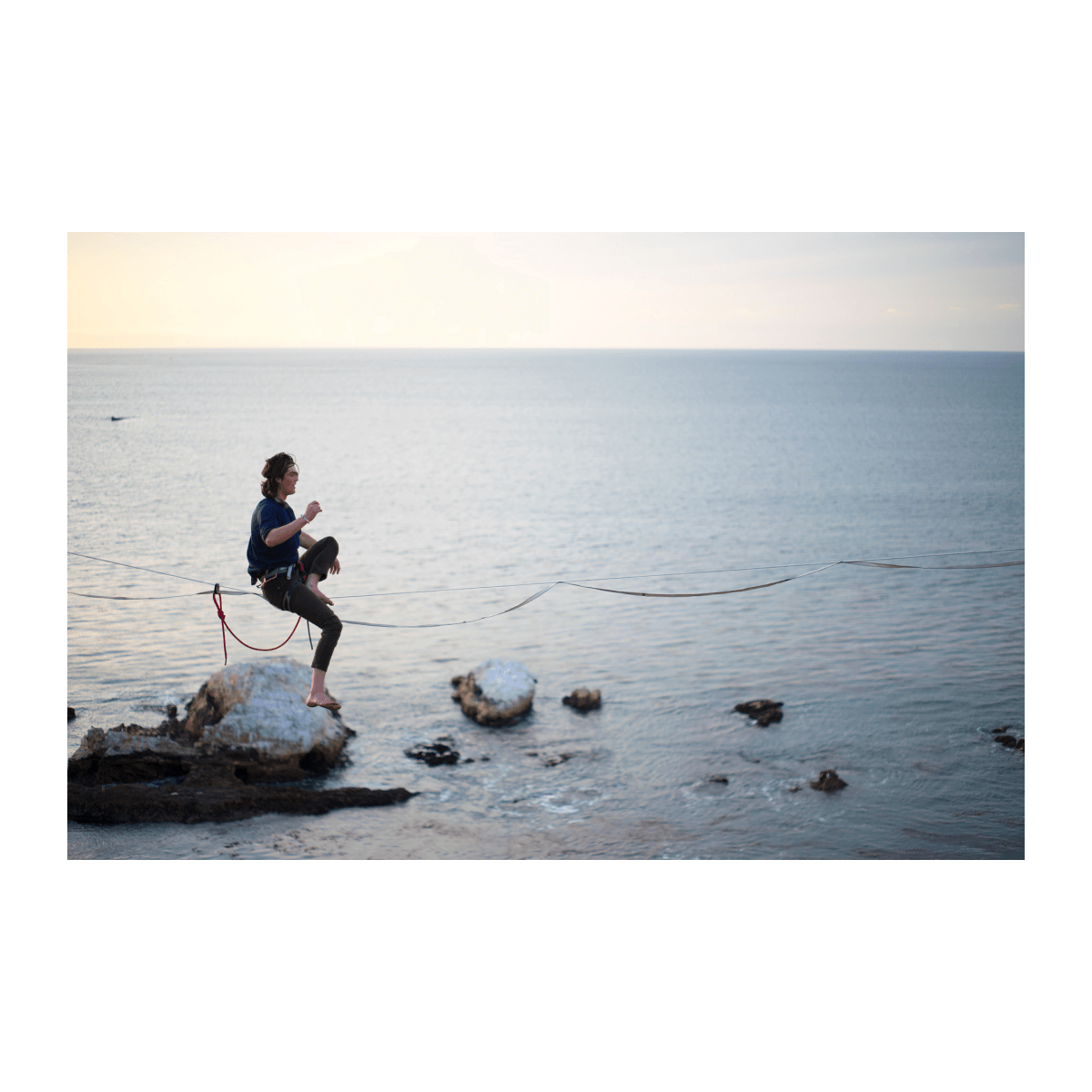 Bract apparel young man balancing on slcak line over ocean in sustainable clothes